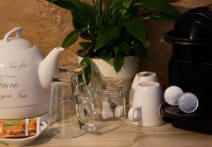 uma mesa com um vaso de plantas e jarros e um vaso em Puurderij B&B en meer... em Nijeveen