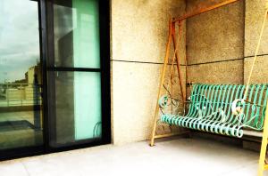 a bench sitting on a balcony next to a window at 花蓮站全民宿-無人民宿自助入住-包棟可烤肉可麻將 in Hualien City