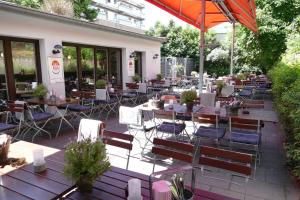 a restaurant with tables and chairs and an umbrella at DAS Steeps Ihr Brauhaus und Hotel in Cologne
