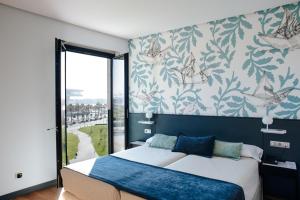 a bedroom with a large bed and a large window at Hotel Neptuno in Valencia