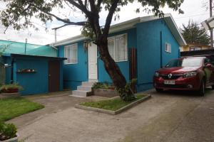 una casa azul con un coche aparcado delante de ella en Casa Pali en Puerto Montt