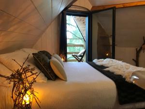 A bed or beds in a room at Les Cabanes de Koad'dour - séjour SPA dans les arbres