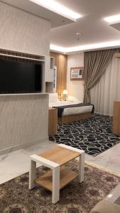 a hotel room with a bed and a television at Juri Ahla Al Masayef Furnished Units in Taif