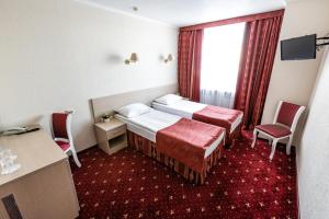 a hotel room with two beds and a window at AMAKS Congress Hotel in Rostov on Don