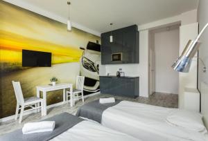 a hotel room with two beds and a tv at Apartamenty Planet in Warsaw