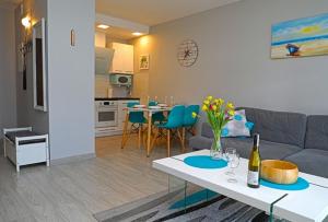 a living room with a couch and a table at Apartament BLUE BAY Darłówko in Darlowko