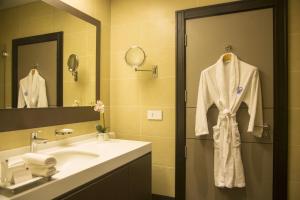 a bathroom with a sink and a mirror at Kin Plaza Arjaan by Rotana in Kinshasa