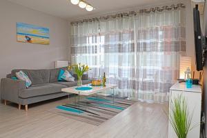 a living room with a couch and a table at Apartament BLUE BAY Darłówko in Darlowko