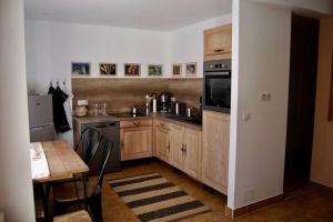 uma cozinha com armários de madeira, uma mesa e um fogão em RASCAS Gîte de Montagne em Briançonnet