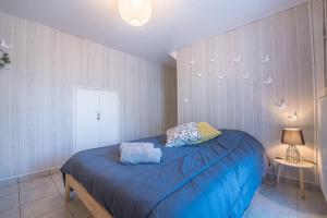 a bedroom with a bed with blue sheets and birds on the wall at La Savouè - Chambre in Francin