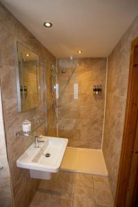 
a bathroom with a sink, toilet and shower at Old Pines Hotel And Restaurant in Spean Bridge
