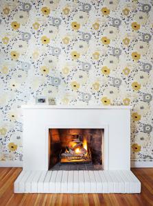 a fireplace in a living room with a floral wallpaper at Casa Legado in Bogotá