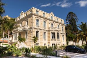 ein Gebäude mit einem davor geparkt in der Unterkunft Villa Genesis in Menton