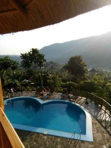 a swimming pool with a view of a mountain at Trackers Safari Lodge Bwindi in Buhoma