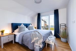 ein Schlafzimmer mit einem blauen Bett und einem Fenster in der Unterkunft Sail Away in Olpenitz