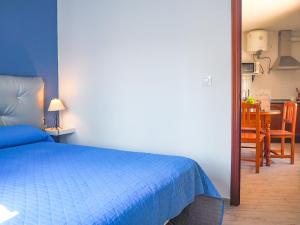 een slaapkamer met een blauw bed en een eetkamer bij ConilPlus apartment SANTA CATALINA II in Conil de la Frontera