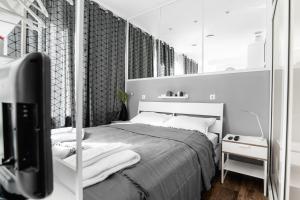a white bedroom with a bed and a mirror at Oxford Apartments in Ljubljana
