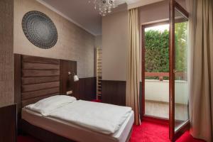 1 dormitorio con cama y ventana grande en Hotel Kristály Imperial, en Tata