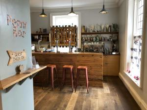 a kitchen with a wooden counter and stools in it at Gomersal Lodge Hotel in Cleckheaton