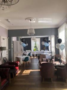 a living room with couches and a dining room at Gomersal Lodge Hotel in Cleckheaton