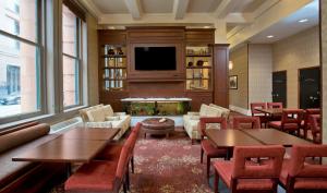 ボルチモアにあるStaybridge Suites Baltimore - Inner Harbor, an IHG Hotelのテーブルと椅子、暖炉のあるレストラン