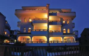 un grande edificio bianco con luci accese di notte di Sea View Apartments Sirena Okrug Gornji a Okrug Gornji