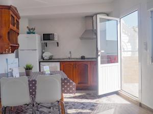 a kitchen with a table and a refrigerator at ConilPlus apartment SANTA CATALINA III in Conil de la Frontera