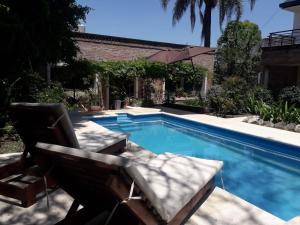 a swimming pool with two lounge chairs next to it at CABAÑAS VILLA CLUB 3 cerca del aeropuerto el palomar in Hurlingham