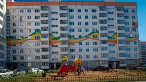ヴェリーキー・ノヴゴロドにあるApartment Moskvichkaの白い大きな建物(遊び場付)