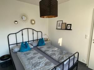 a bed with blue pillows on it in a room at Ferienwohnung Vöst in Weil