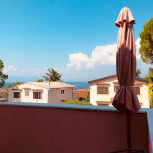 a closed umbrella sitting on the edge of a balcony at Apartmani HILA in Njivice