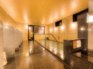 - un couloir avec piscine d'eau dans un bâtiment dans l'établissement APA Hotel Takaoka Ekimae, à Takaoka