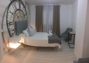 een slaapkamer met een bed met een stoel en een spiegel bij CASA DE TOSCA in Lucena