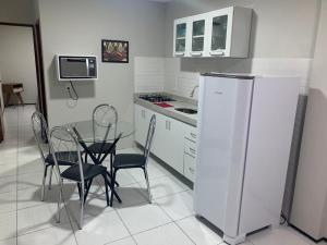 eine Küche mit Tisch und Stühlen und einem Kühlschrank in der Unterkunft Pousada Residencial Milagre 101 in Juazeiro do Norte