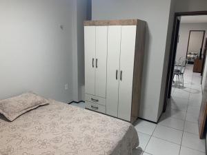 ein Schlafzimmer mit einem Bett und einem weißen Schrank in der Unterkunft Pousada Residencial Milagre 101 in Juazeiro do Norte