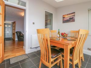comedor con mesa de madera y sillas en 8 Coastguard Cottages en Dawlish