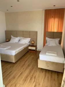 two beds sitting next to each other in a bedroom at MIMOZA - Apartaments Panoramic Sea View in Eforie Nord
