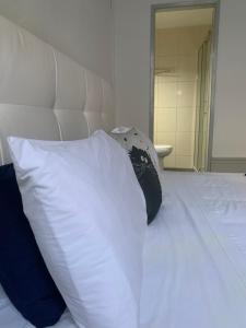 een wit bed met een zwart-wit kussen bij Residência Céu Azul in Porto