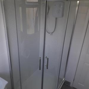 a shower with a glass door in a bathroom at Chalet Driftwood in Sandown