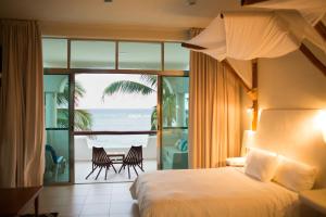 - une chambre avec un lit et une vue sur l'océan dans l'établissement Paamul Hotel, à Palmul