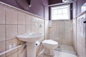 um banheiro com uma pia, um vaso sanitário e uma janela em Grand Residences Pousadas em Campos de Jordão mais 74 fotografias