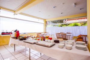 uma mesa longa com pratos e pratos em Grand Residences Pousadas em Campos de Jordão