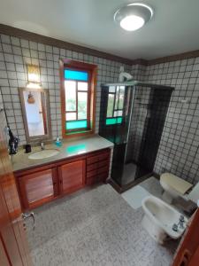 a bathroom with a sink and a shower and a toilet at Casa Larrosa Itaúna Adults Only in Saquarema