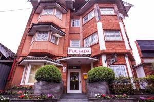 um edifício de tijolos vermelhos com um sinal em Grand Residences Pousadas em Campos de Jordão