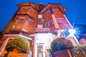 a tall brick building with a sign on it at Grand Residences Pousadas in Campos do Jordão