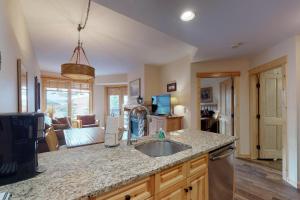 a kitchen with a sink and a living room at Tucker Mountain Lodge 321 in Copper Mountain