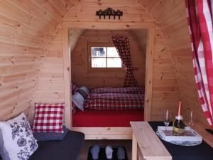 a small bedroom in a wooden cabin with a bed at Romantischer POD - Optional mit Hotpot - Whirlpool in Hohenberg an der Eger