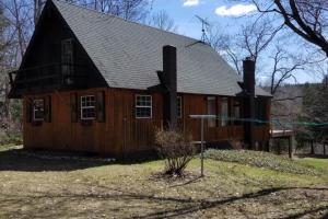 a large wooden house with a gambrel roof at Betsie River Getaway in Thompsonville