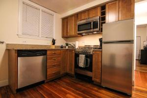 a kitchen with stainless steel appliances and wooden cabinets at Stylish 1BR in Malden #3 in Malden +24 photos