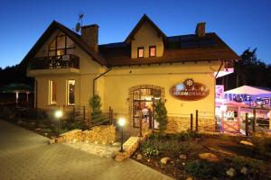 a building with a sign on the side of it at Apartamenty & Restauracja NADMORSKA in Krynica Morska